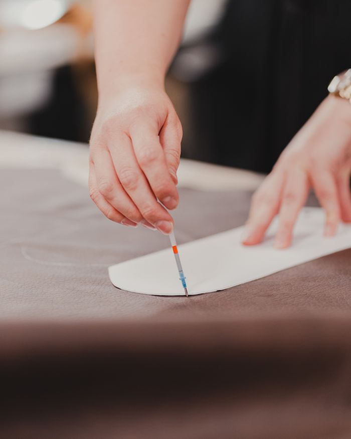 Close-up of a tailors hand carefully measuring fabric for garment creation.